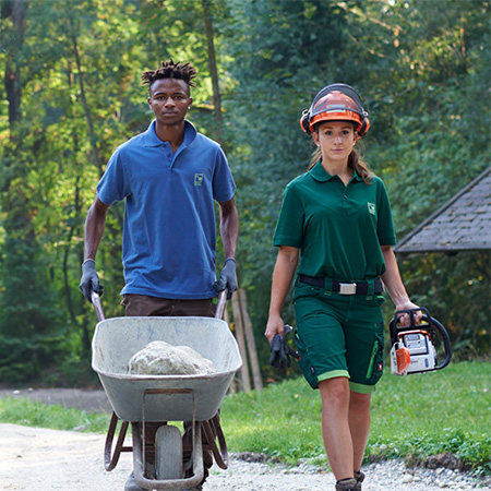 Zwei Landschaftsgärtner laufen zu einem Bauprojekt